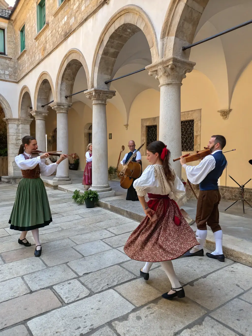 A photograph of a musical performance taking place in the courtyard of the Abbaye de Beauport, with musicians playing traditional instruments.